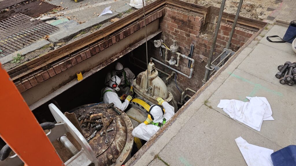 SE Asbestos Surveys team in protective suits carrying out specialist hazardous materials work in an old brick chamber